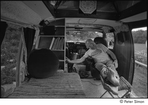 Ram Dass in his van: Ram Dass seated with his feet up