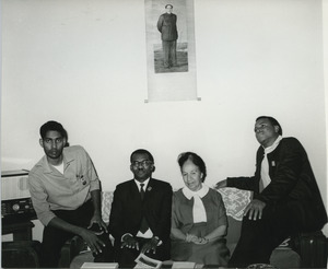 Shirley Graham Du Bois sitting on a couch with three unidentified men