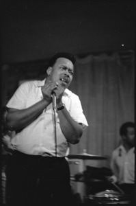 James Cotton at Club 47: James Cotton holding harmonica and microphone onstage with Luther Tucker playing guitar behind him at left, and Francis Clay playing drums at right