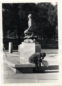 Man seated by Parkman Plaza Religion Sculpture, Boston Common