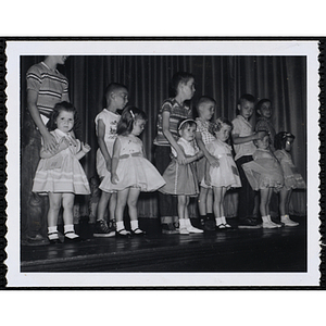 Six girls and their brothers standing together on the stage during a Boys' Club Little Sister Contest
