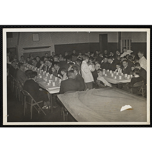 Men and boys sit at tables during a Dad's Club banquet