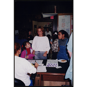 A Woman with a young girl signing up for a swimming activity