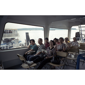Chinese Progressive Association members seated in a group on a ferry