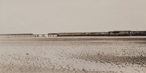 View of an expanse of mudflats, a viaduct in the distance, port of Zeebrugge, Belgium
