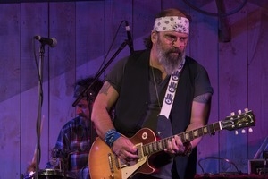 Steve Earle (guitar) performing onstage with Steve Earle and the Dukes at the Payomet Performing Arts Center