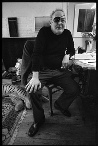 W. Eugene Smith, seated at a desk in his home