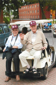 Two members of the Class of 1952 on back of golf cart