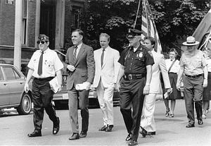 Mayor Raymond L. Flynn marching in the Bunker Hill Day Parade in Charlestown with parade organizer James Conway, Metropolitan District Commission Officer Bill Connell, State Senator Richard Voke and others