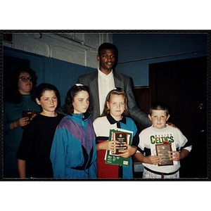 Former Boston Celtic Reggie Lewis posing for a group picture with a boy and four girls at a Kiwanis Awards Night