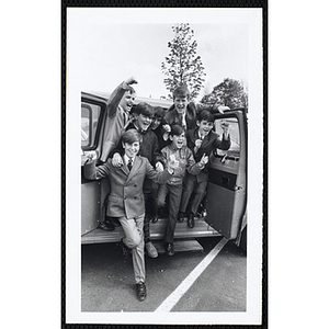 Seven Boys' Club members in suits cheering from a car