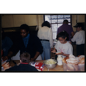 Linda Bayland (left) and Madeline Bonilla (right) make sandwiches in a kitchen