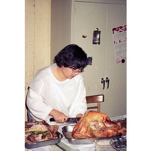 Woman carves a turkey for a dinner at the Chinese Progressive Association Workers' Center