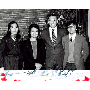 Mayor Ray Flynn (3rd from left) stands in front of a Christmas tree with the Chinese Progressive Association director Suzanne Lee (2nd from left), and two unidentified people at a celebration after the victory in the Long Guang Huang case