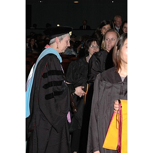 Faculty member guides student procession into School of Nursing convocation