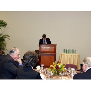 Dr. Ira R. Weiss at podium speaking before guests of the College of Business Administration's Distinguished Service Awards