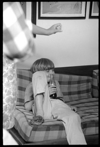 Teenage long hair: young boy watching the dance party from a couch, Coca Cola in hand