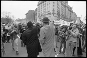 Two counter-protesters in suits give a thumbs down to anti-Vietnam War protesters during the Counter-inaugural demonstrations, 1969
