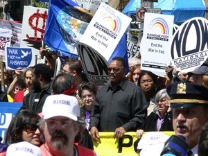 Jesse Jackson in the midst of the crowd of antiwar marchers in the streets of New York, with signs and banners opposing the war in Iraq