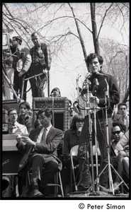Resistance on the Boston Common: Terry Cannon (draft resister and member of the Oakland 7) addressing the crowd, Howard Zinn checking his notes on stage (far left)