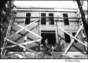 James Taylor's house: group sitting in the doorway of Taylor's under construction house