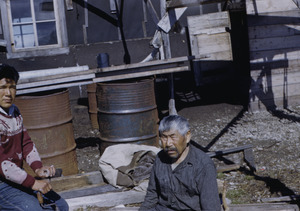 Father and son outside their home working