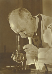 Charles A. Peters with a microscope