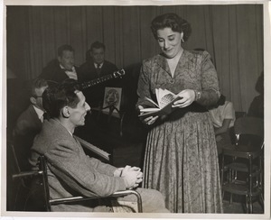 Young man, seated in wheelchair, and Kay Armen at an event naming her an honorary member of club can do