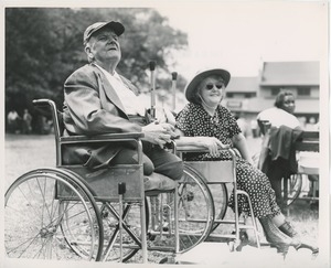 Man and woman in wheelchairs watch event at annual outing
