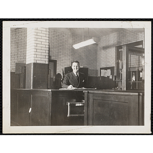 A Boys' Club staff member smiles for the camera, seated at his desk