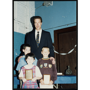 Former Boston Celtic Dave Cowens posing for a group picture with two boys and a girl at a Kiwanis Awards Night
