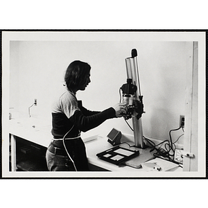 A woman using an enlarger at a photographic laboratory