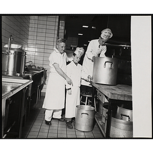 Two members of the Tom Pappas Chefs' Club and a cook work with stock pots in a Howard Johnson's kitchen