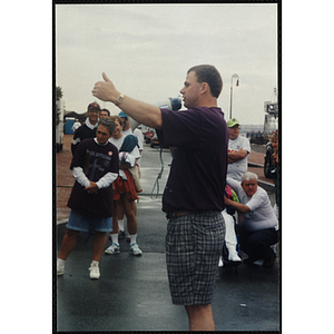 A man addresses a crowd of people with a megaphone during the Battle of Bunker Hill Road Race