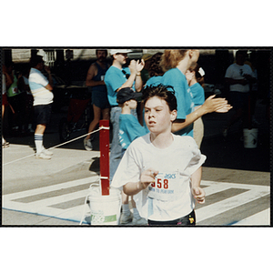 A boy crosses the finish line during the Battle of Bunker Hill Road Race