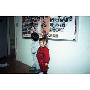 Young girl and boy at the Chinese Progressive Association office during a holiday party