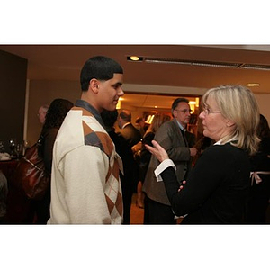 Danny Vazquez converses with a woman at a Torch Scholars event