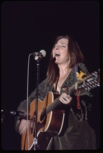 Judy Collins: in green velvet dress with guitar, performing on stage