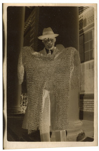 W. E. B. Du Bois posing with suit of armor in front of Harkness Hall