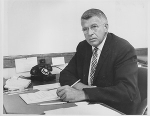 William B. Esselen sitting indoors, working behind desk