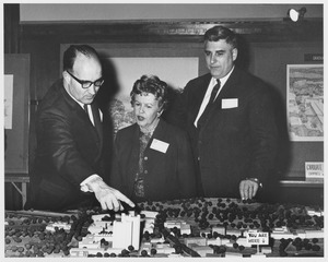 Edward C. Moore with Ruth Phillips and an unidentified man looking at a scale model of the Graduate Research Center