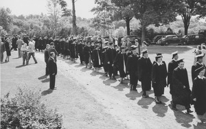 Graduates in outdoors procession on their way to Curry Hicks Cage