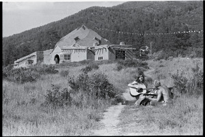 Lama Foundation Community: men playing guitar in the fields, the Dome in the background