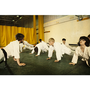 Students stretching on the ground during a martial arts class