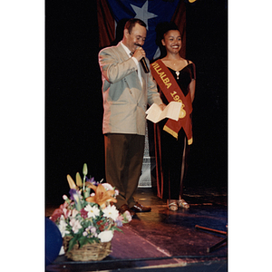 A man speaks into a microphone while standing with Damaris Padilla at the Festival Puertorriqueño