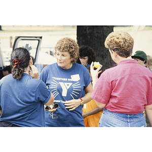 Women in Young Men's Christian Association shirts have a conversation