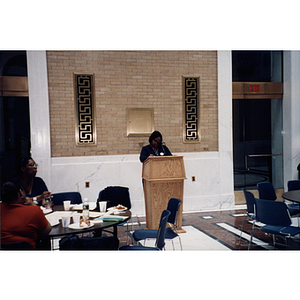 A woman speaks at the lectern at a town meeting