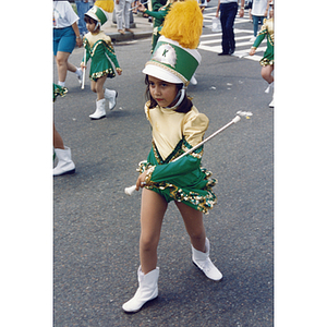 A girl walks with a baton in a parade for the Festival Puertorriqueño