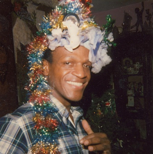 A Photograph of Marsha P. Johnson Wearing a Headpiece Made of Tinsel and Flowers