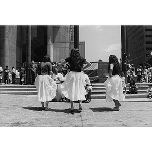 Three women dance in Boston's City Hall Plaza